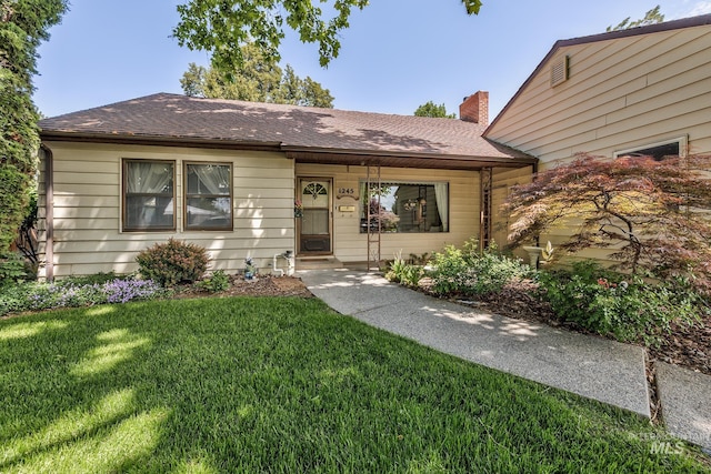 1245 SW 3rd Ave, Ontario, OR 97914 - view of front of house featuring a front lawn, a shingled roof, and a chimney