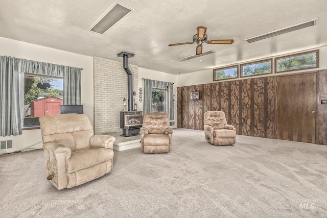 1245 SW 3rd Ave, Ontario, OR 97914 - living area with a wood stove, carpet, a ceiling fan, and healthy amount of natural light