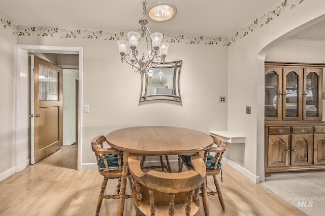 1245 SW 3rd Ave, Ontario, OR 97914 - dining space with a chandelier, arched walkways, light wood-style floors, and baseboards