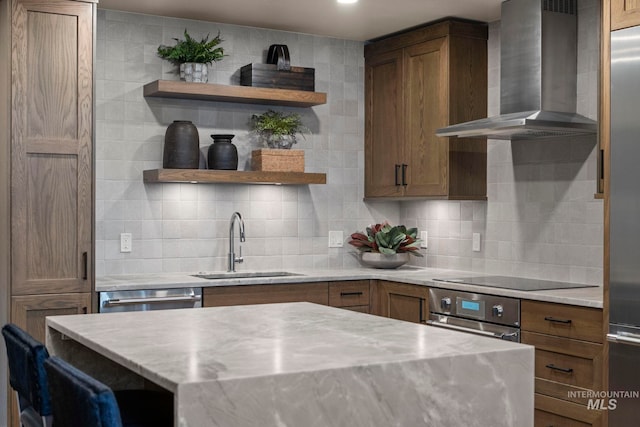 kitchen with tasteful backsplash, sink, appliances with stainless steel finishes, and wall chimney exhaust hood