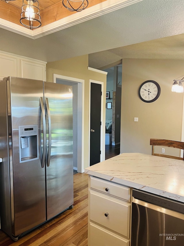 kitchen featuring appliances with stainless steel finishes, wood finished floors, light countertops, and white cabinets