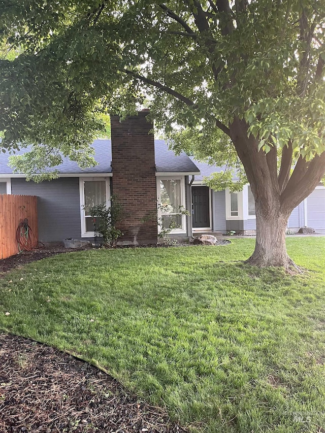 view of front of home featuring a chimney and a shingled roof