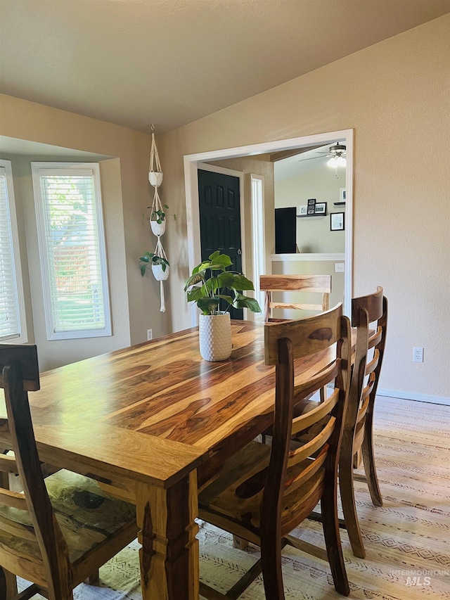 dining area featuring light wood-style floors, baseboards, and ceiling fan