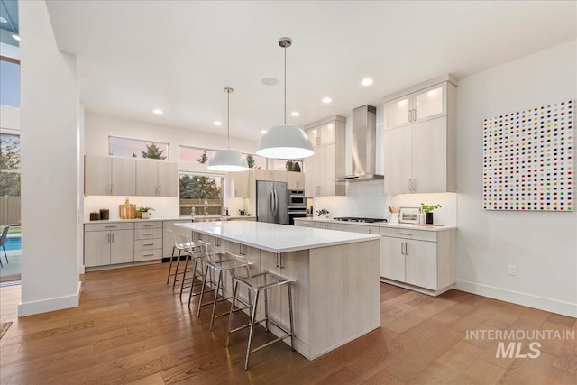 1891 E Golden Oak Ct, Meridian, ID 83646 - kitchen with wall chimney range hood, freestanding refrigerator, gas cooktop, a breakfast bar area, and a sink