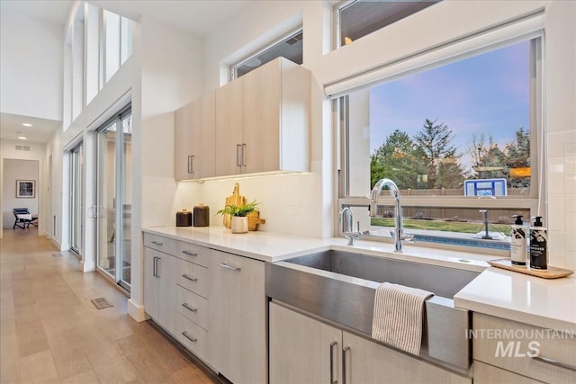 1891 E Golden Oak Ct, Meridian, ID 83646 - kitchen with a sink, light countertops, tasteful backsplash, light wood-style flooring, and a high ceiling