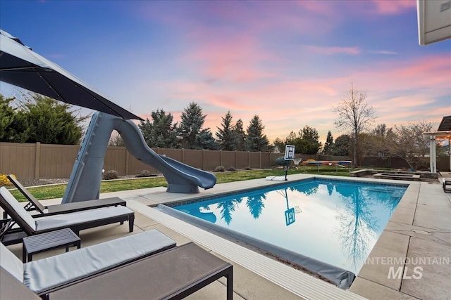 1891 E Golden Oak Ct, Meridian, ID 83646 - pool at dusk featuring a water slide, a fenced backyard, and a patio area