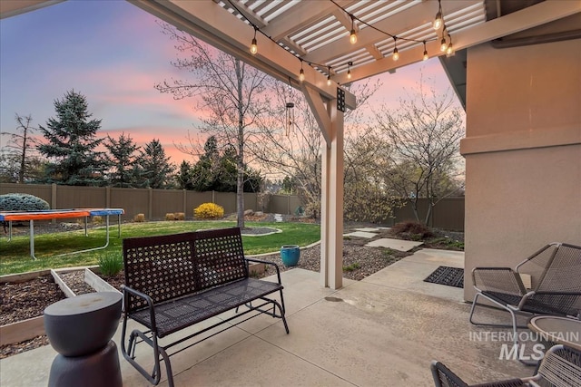 1891 E Golden Oak Ct, Meridian, ID 83646 - patio terrace at dusk featuring a trampoline, a patio area, and a pergola