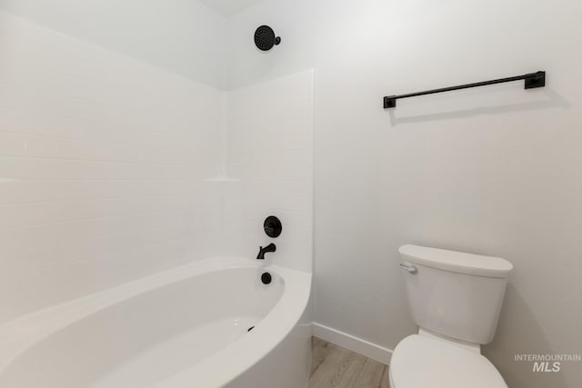 full bath featuring baseboards, bathing tub / shower combination, toilet, and wood finished floors