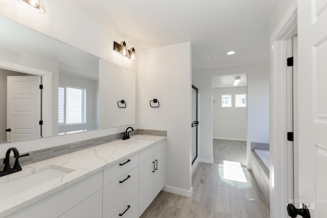 full bath featuring a wealth of natural light, a shower stall, and a sink