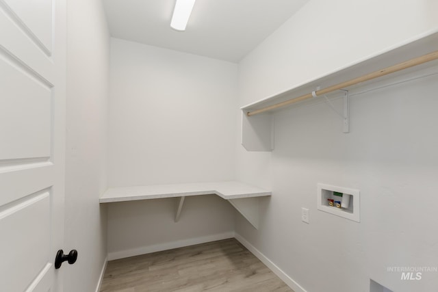 laundry area featuring laundry area, washer hookup, light wood-style flooring, and baseboards