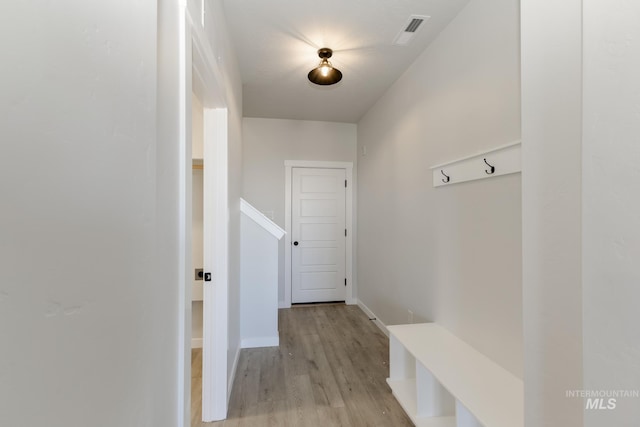 mudroom featuring baseboards, visible vents, and light wood-style floors