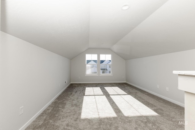 additional living space featuring lofted ceiling, baseboards, and carpet