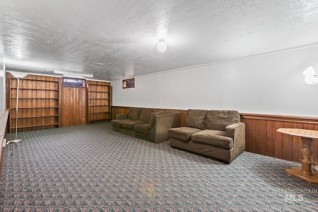 unfurnished living room with a textured ceiling, dark carpet, and wooden walls