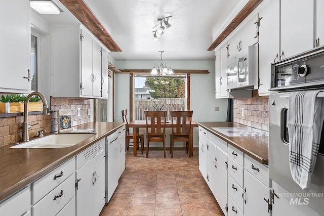 kitchen featuring white cabinetry, white appliances, and decorative light fixtures