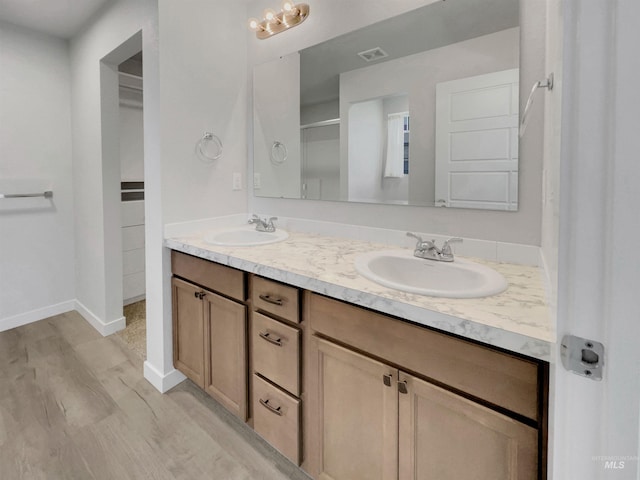 5394 N Elmstone Ave, Meridian, ID 83646 - full bath with double vanity, wood finished floors, a shower with shower door, and baseboards
