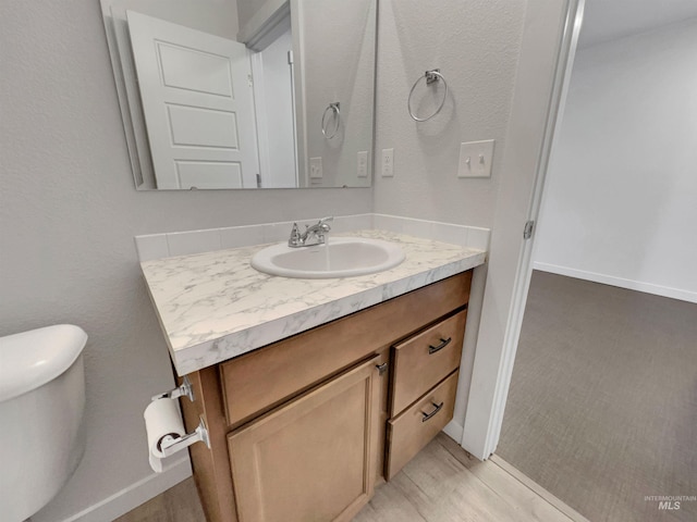 5394 N Elmstone Ave, Meridian, ID 83646 - half bath featuring vanity, toilet, wood finished floors, and baseboards