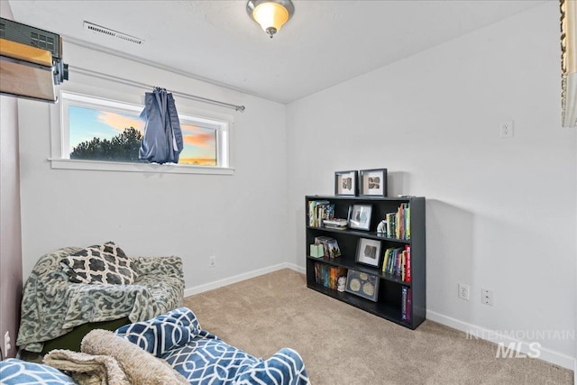 living area featuring a healthy amount of sunlight, baseboards, visible vents, and carpet flooring