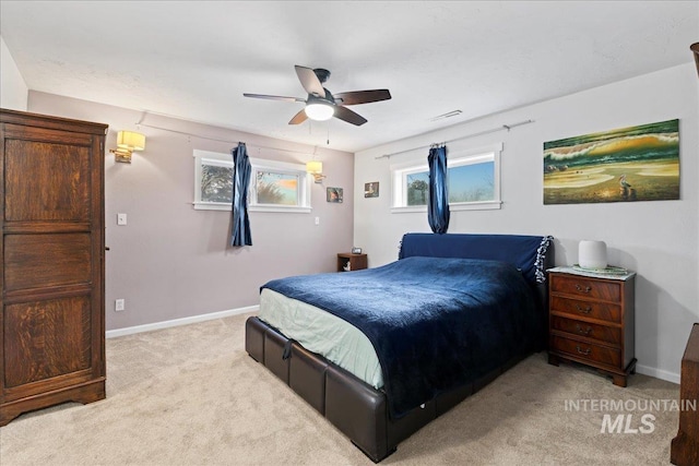 bedroom featuring ceiling fan, visible vents, baseboards, and light colored carpet