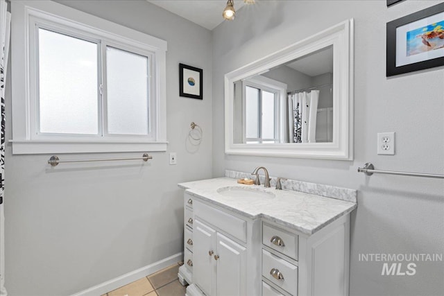 bathroom with vanity, baseboards, and tile patterned floors