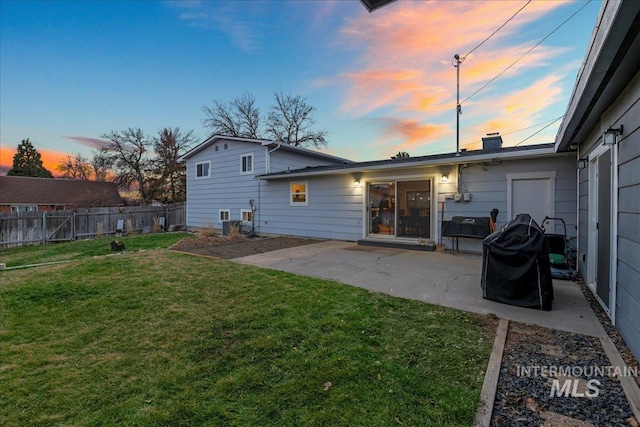 back of house with a yard, a chimney, a patio area, and fence