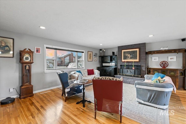 living area featuring light wood finished floors, visible vents, baseboards, and recessed lighting