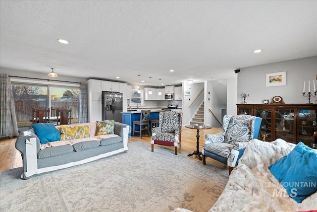 living area with stairway, light wood-type flooring, and recessed lighting