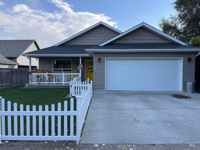 view of front of house with a garage, a front lawn, and covered porch