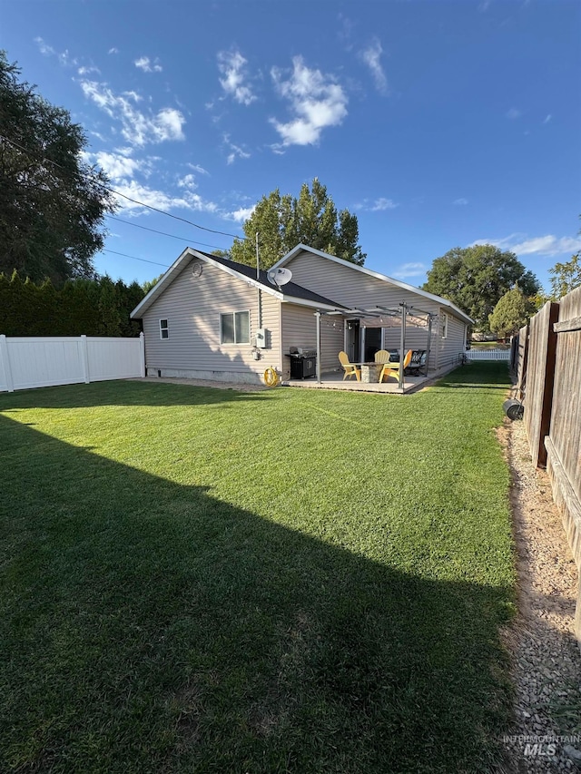 back of house with a lawn and a patio