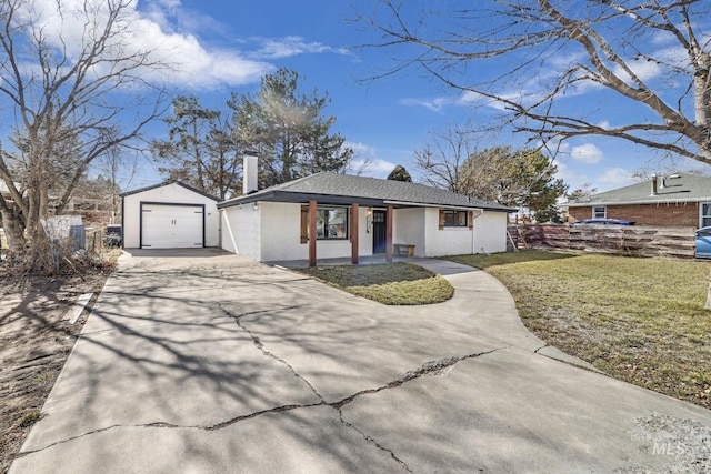 ranch-style house featuring an outbuilding, covered porch, a front yard, a garage, and driveway