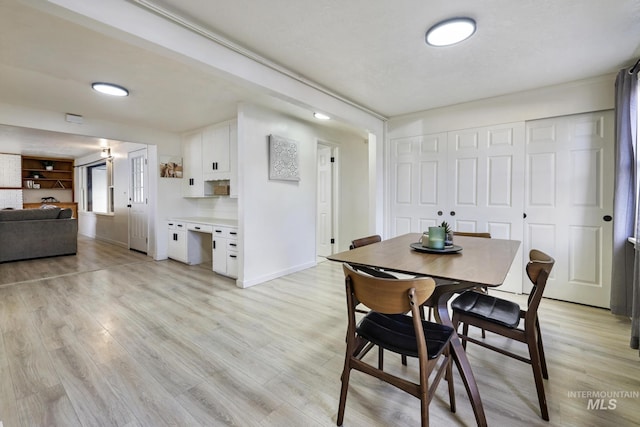 dining area with baseboards and light wood-style floors