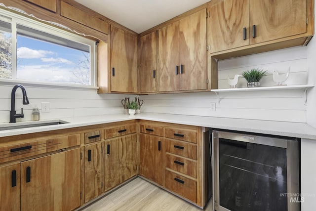 kitchen featuring brown cabinetry, wine cooler, light countertops, open shelves, and a sink