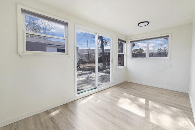 spare room with light wood-type flooring and baseboards