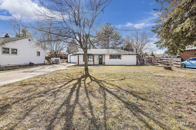 view of front of home featuring a garage, concrete driveway, fence, and a front lawn