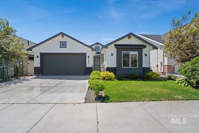view of front of property featuring board and batten siding, a garage, a front lawn, concrete driveway, and stone siding