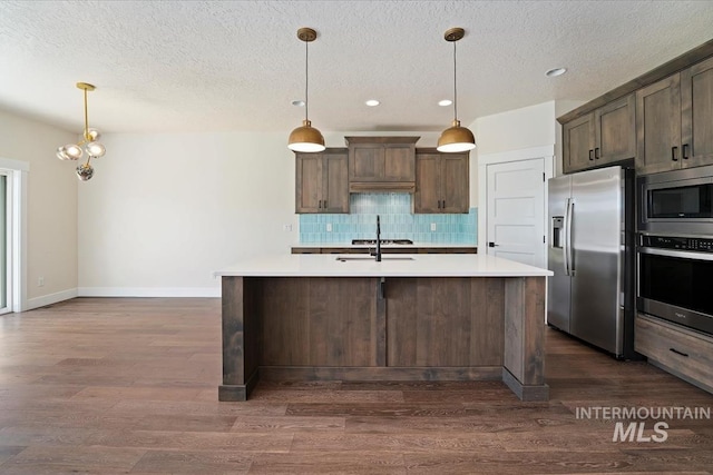kitchen featuring appliances with stainless steel finishes, a textured ceiling, light countertops, decorative backsplash, and recessed lighting