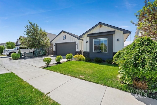 view of front of property with board and batten siding, driveway, a front lawn, and a garage