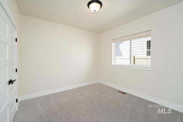 empty room featuring carpet and baseboards