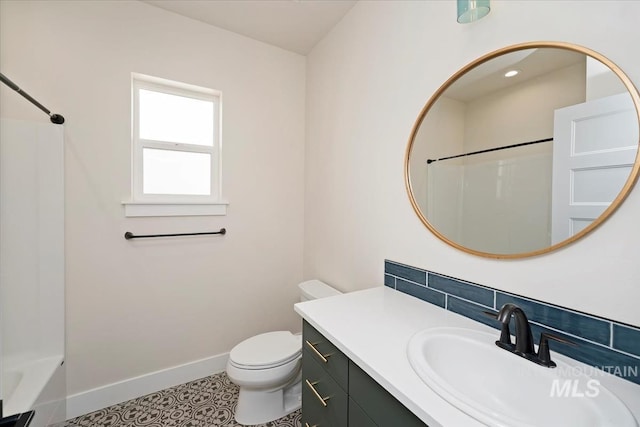 bathroom with tasteful backsplash, baseboards, vanity, and toilet