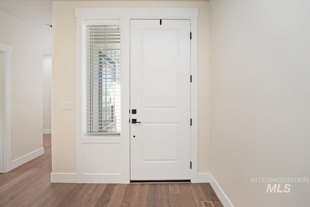 entryway featuring baseboards and wood finished floors