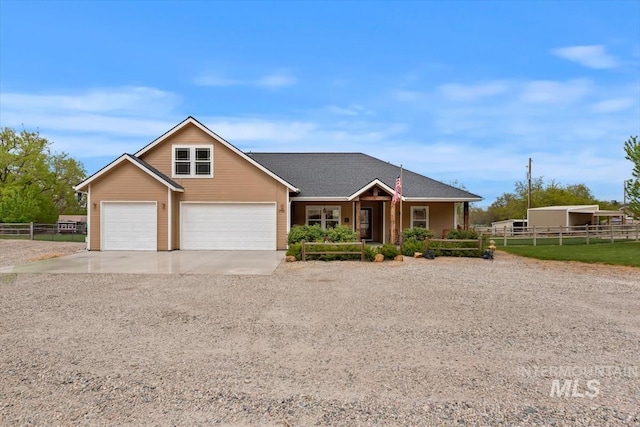 view of front of house featuring fence, covered porch, driveway, and a garage