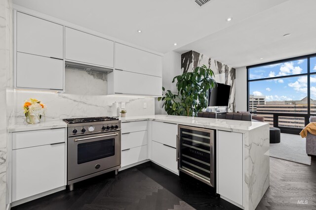 255 S Capitol Blvd Unit 1403, Boise, ID 83702 - kitchen with high end stainless steel range oven, beverage cooler, a peninsula, modern cabinets, and decorative backsplash