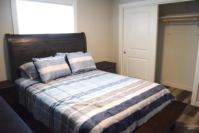 bedroom with baseboards, a closet, and wood finished floors
