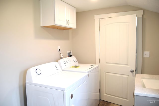 washroom featuring cabinet space, independent washer and dryer, a sink, and wood finished floors