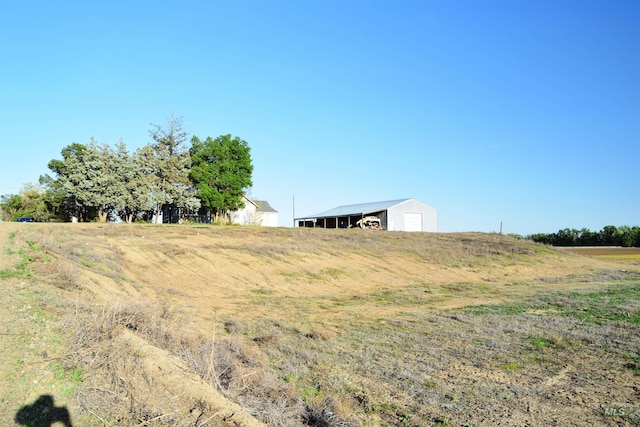 view of yard featuring a garage, an outbuilding, and a pole building