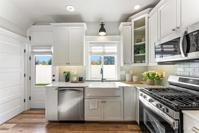 kitchen featuring glass insert cabinets, white cabinetry, appliances with stainless steel finishes, and light countertops