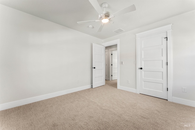 unfurnished bedroom with light colored carpet, ceiling fan, visible vents, and baseboards