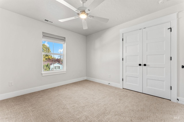 unfurnished bedroom featuring baseboards, visible vents, a closet, and light carpet