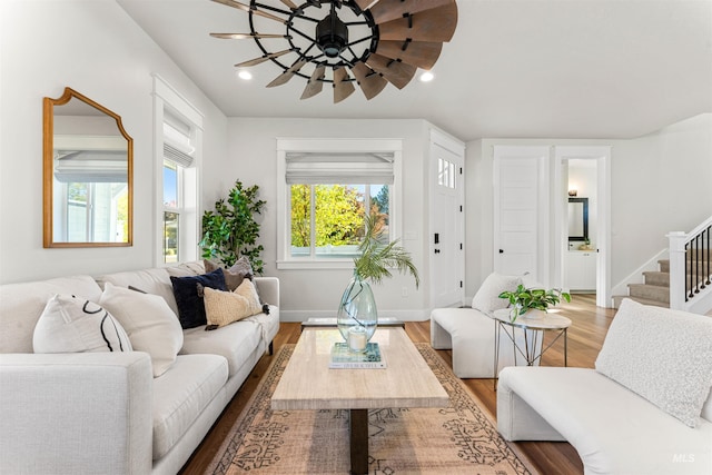 living area featuring stairway, a ceiling fan, wood finished floors, baseboards, and recessed lighting