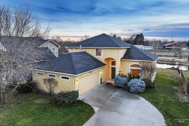 front of property featuring a lawn and a garage