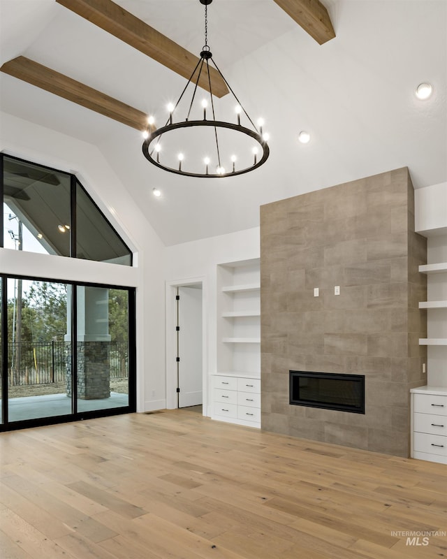 11444 N 17th Way, Boise, ID 83714 - unfurnished living room with beamed ceiling, wood finished floors, high vaulted ceiling, built in shelves, and a chandelier